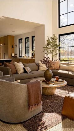 a living room filled with furniture and large windows