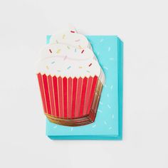 a cupcake with sprinkles is on a blue napkin