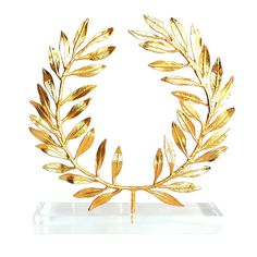 a gold leaf wreath on a clear base