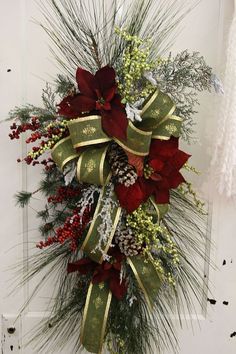 a christmas wreath with red flowers and greenery