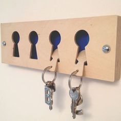 several keys are hanging on the wall with hooks