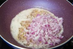 onions being cooked in a frying pan on the stove with oil and seasonings