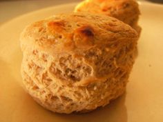 two biscuits sitting on top of a white plate next to an orange and black object