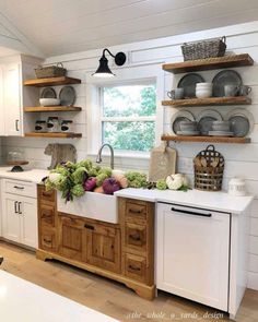 a kitchen filled with lots of wooden shelves next to a white stove top oven and dishwasher