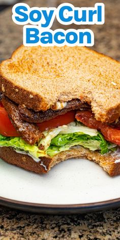 a sandwich with bacon, lettuce and tomato on it sitting on a plate