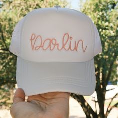 The perfect Darlin trucker hat! The trucker hat is embroidered in pink thread using a western rope font.  About the Hat: White foam with mesh back. Snapback closure. Rope Font, Which Hat, Hurley Hats, White Trucker Hat, White Bucket Hat, Hat Western, Pink Thread, Minnie Mouse Bow, Wide Brim Fedora