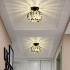 two lights are hanging from the ceiling in this hallway with white walls and flooring