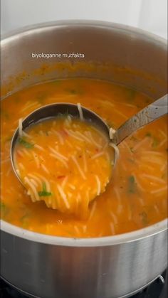 a ladle full of soup being stirred by a spoon