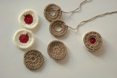 four crocheted objects are sitting on a table with string and yarn in the shape of circles