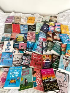 a bed covered in lots of books sitting next to each other