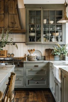 a kitchen with gray cabinets and wooden floors