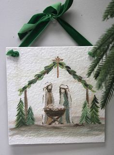 a nativity scene is hanging on the wall next to a christmas tree and green ribbon