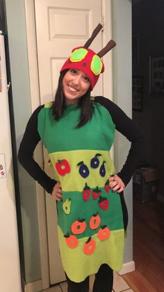 a woman wearing a costume made to look like a caterpillar with apples on it