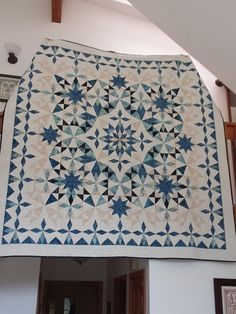 a blue and white quilt hanging from the ceiling