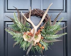 a wreath with antlers and flowers on the front door