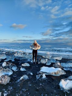 a woman standing on top of an ice covered beach