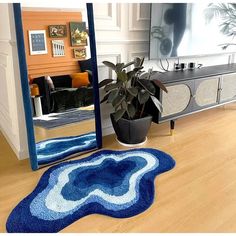 a blue rug is in front of a mirror with a potted plant on it