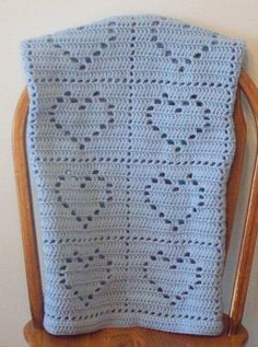 a crocheted blanket sitting on top of a wooden chair