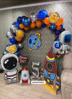 an astronaut balloon arch with balloons around it and other decorations on the wall behind it