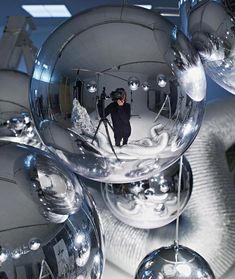 a person standing in front of some shiny balls