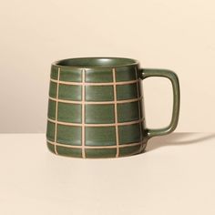 a green mug sitting on top of a table