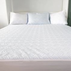 the bed is made with white sheets and pillows