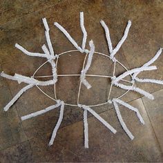 a circular piece of string art with white sticks sticking out of it's center