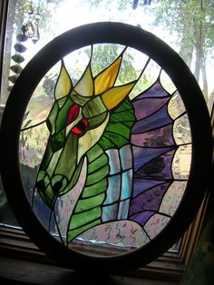 a circular stained glass window with a green dragon on it's head and red eyes