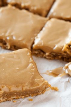 peanut butter bars with frosting sitting on top of a piece of white parchment paper