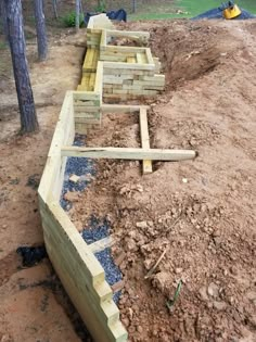 a wooden fence is being built in the dirt