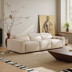 a living room filled with furniture and a large painting on the wall above the couch