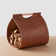 a brown leather bag filled with logs