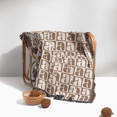 a brown and white blanket sitting on top of a wooden chair next to a basket