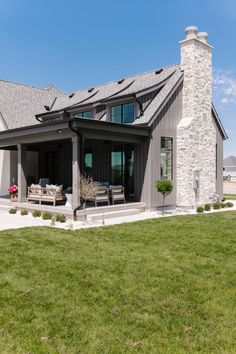 a house with a large lawn in front of it and a stone chimney on the side