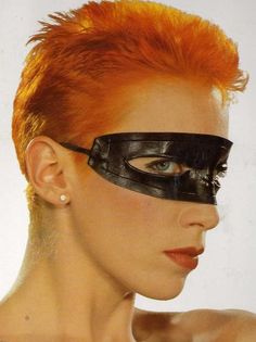 a woman with red hair wearing a mask