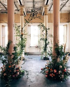 an empty room with columns and flowers on the floor