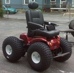 an image of a red lawn tractor with big tires on it's front wheel