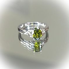 Top Of Ring Height: 8.0mm Top Of Ring Width: 6.0mm Band Width: 2.7mm Shank Width: 1.6mm Stone Material: Peridot Cubic Zirconia Center Stone Size: 8.0mm X 6.0mm Stone Shape: Oval Center Stone Carat Weight: 1.21 Ct Stone Setting: Prong Metal: 925 Sterling Silver Plating: Rhodium Plated Finish: High Polish Alt Rooms, Heart Knot Ring, Green Wedding Rings, Peridot Engagement Rings, Dainty Wedding Ring, Big Stone Ring, Dream Future, Unique Rings Vintage, Stone Material