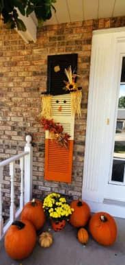 some pumpkins are sitting on the front porch