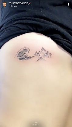 a woman's stomach with a tattoo on it that has mountains in the background