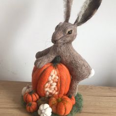 a stuffed rabbit sitting on top of a pumpkin