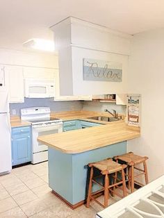 a kitchen with an island counter and stools next to the stove top oven, refrigerator and dishwasher