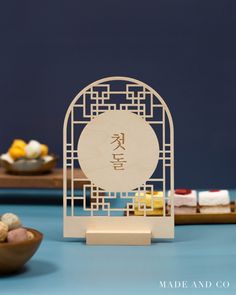 a small wooden stand with some food on the table next to other plates and bowls