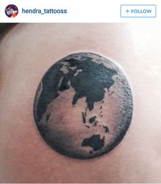 a black and white photo of the earth tattoo on someone's back side shoulder