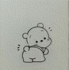 a drawing of a teddy bear sitting on top of a white wall with black ink