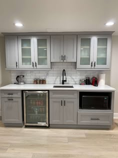 a kitchen with gray cabinets and white counter tops