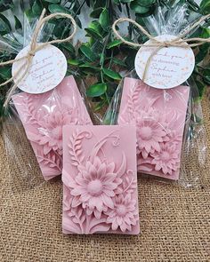 three pink soaps with flowers on them