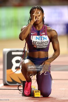 a female athlete sitting on the ground with her head in her hands