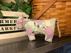 a stuffed toy horse sitting on top of a wooden shelf next to a basket and plant