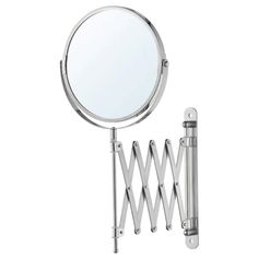 a magnifying mirror is hanging on the wall next to a metal rack with hooks